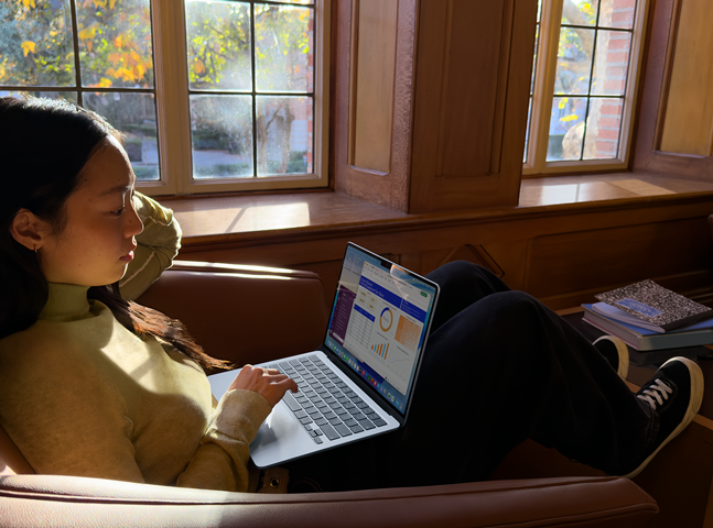 A person sitting in a chair using their MacBook Air